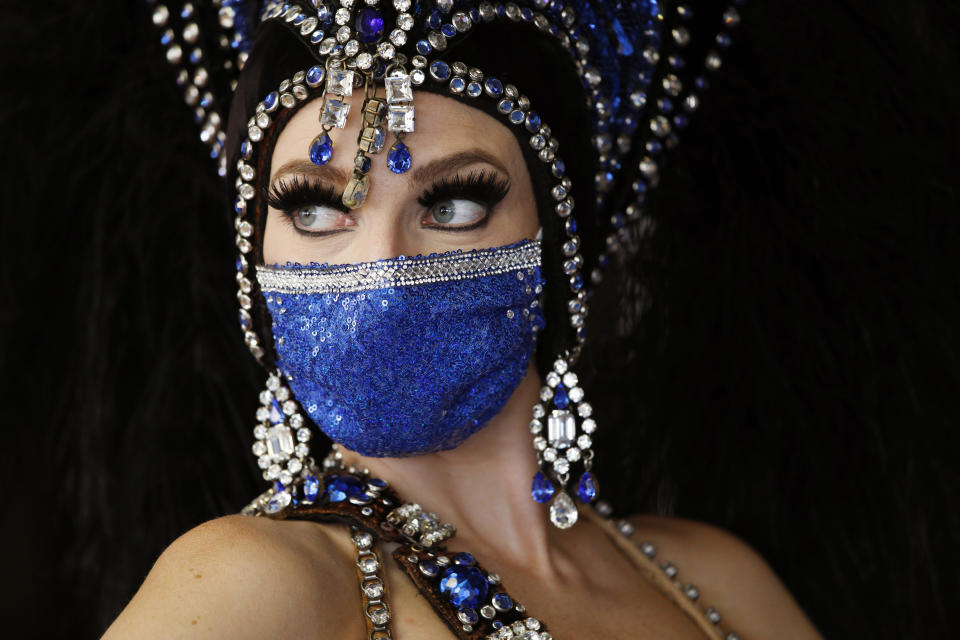 A show performer in a face mask stands by the door at the reopening of Bally's Las Vegas hotel and casino, Thursday, July 23, 2020, in Las Vegas. The casino reopened for the first time since March following a closure to prevent the spread of the coronavirus.  (Photo: ASSOCIATED PRESS)