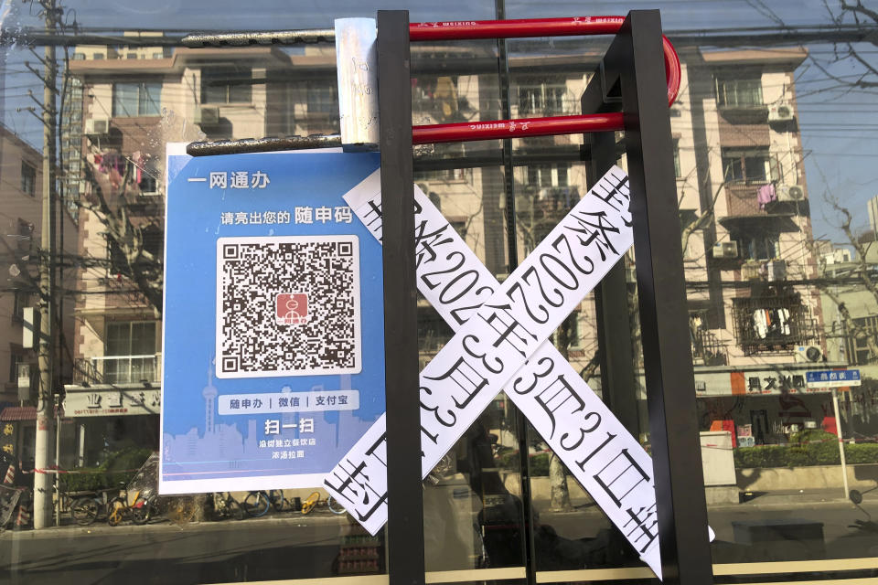 The entrance to a noodle store is locked and sealed in the Jingan district of western Shanghai, Monday, April 4, 2022. China has sent more than 10,000 health workers from across the country to Shanghai, including 2,000 military medical staff, as it struggles to stamp out a rapidly spreading COVID-19 outbreak in China's largest city. (AP Photo/Chen Si)