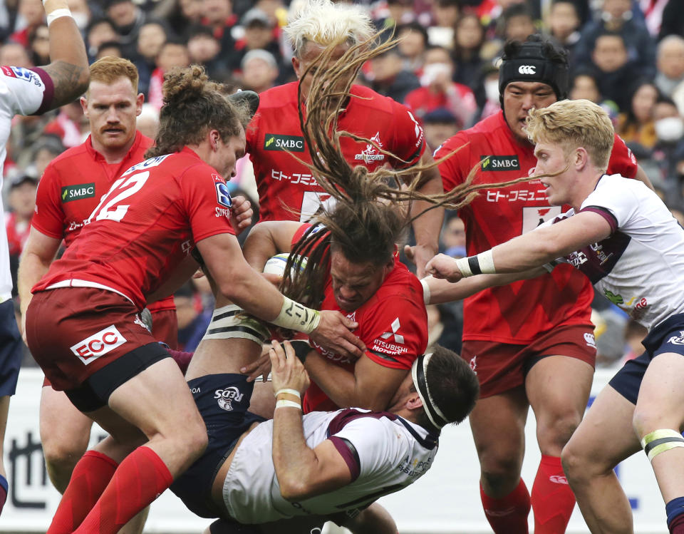 FILE - In this March 16, 2019, file photo, Dan Pryor of Sunwolves, center, holds the ball during their Super Rugby match against Reds in Tokyo. Super Rugby's governing body announced Friday, March 22, 2019 that Japan's Sunwolves will be cut from the competition at the end of the 2020 season. (AP Photo/Koji Sasahara, File)