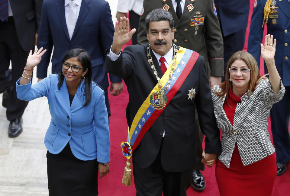 FILE - In this May 24, 2018 file photo, Venezuela's President Nicolas Maduro, then Constituent National Assembly President Delcy Rodriguez, left, and first lady Cilia Flores, wave as they arrive to the National Assembly, in Caracas, Venezuela. The Trump administration slapped financial sanctions Tuesday, Sept. 25, 2018, on four members of Maduro’s inner circle, including his wife, and Rodriguez who is now the nation’s vice president, on allegations of corruption. (AP Photo/Ariana Cubillos, File)