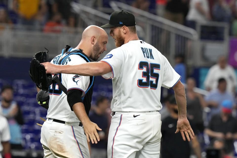 Miami Marlins catcher Jacob Stallings (58) and relief pitcher A.J. Puk (35) celebrate after a baseball game against the San Francisco Giants, Tuesday, April 18, 2023, in Miami. (AP Photo/Lynne Sladky)