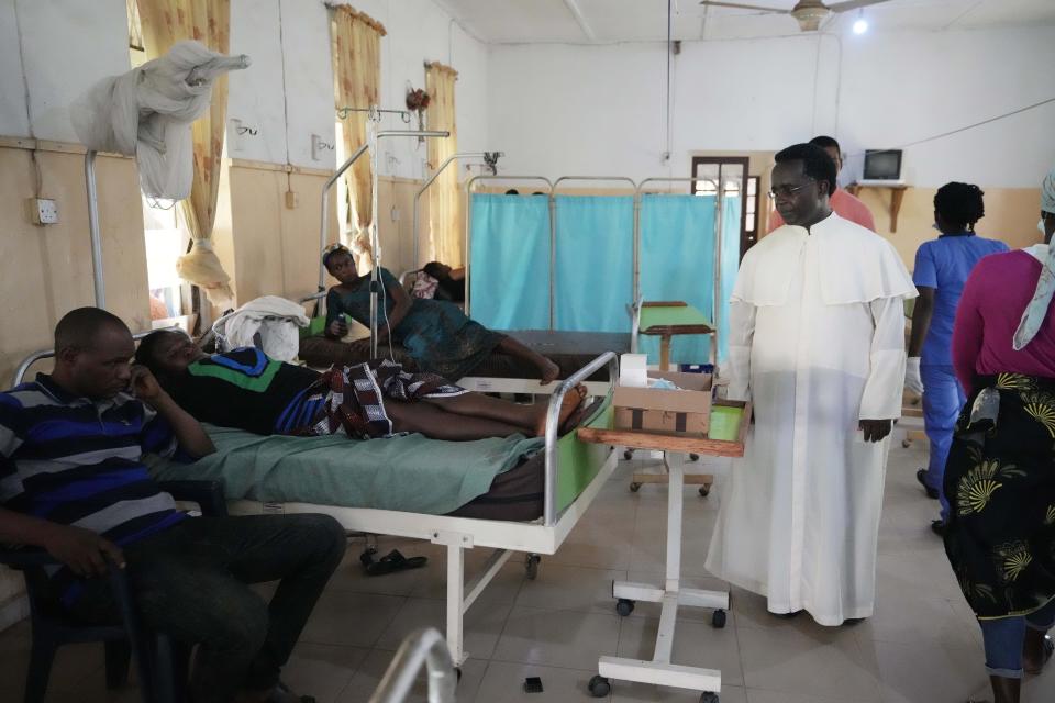 A Catholic Priests pays a visit to victims of St. Francis Catholic Church attack receiving treatment at St Louis Catholic Hospital in Owo Nigeria, Monday, June 6, 2022. Lawmakers in southwestern Nigeria say more than 50 people are feared dead after gunmen opened fire and detonated explosives at a church. Ogunmolasuyi Oluwole with the Ondo State House of Assembly said the gunmen targeted the St Francis Catholic Church in Ondo state on Sunday morning just as the worshippers gathered for the weekly Mass. (AP Photo/Sunday Alamba)