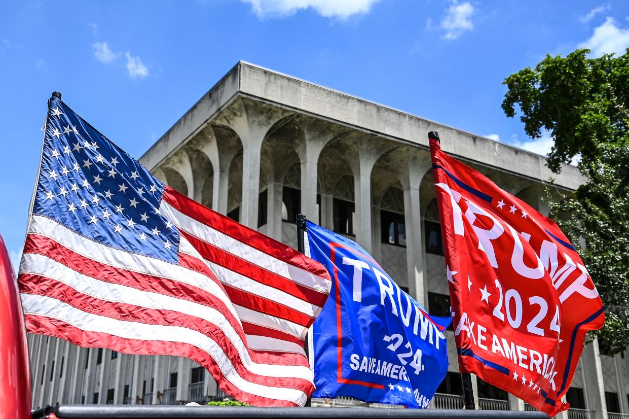 Supporters of former President Donald Trump drive around the Paul G. Rogers Federal Building in West Palm Beach, Fla., on Aug. 18 as a U.S. District Court holds a hearing to determine if the affidavit used by the FBI as justification for the search of Trump's Mar-a-Lago estate should be unsealed. 