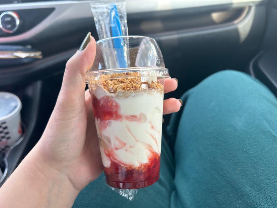 hand holding a strawberry cheesecake sundae from checkers