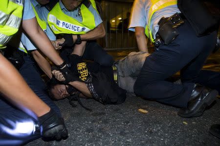 A pro-democracy activist is detained by the police during a confrontation outside the hotel where China's National People's Congress (NPC) Standing Committee Deputy General Secretary Li Fei is staying, in Hong Kong September 1, 2014. REUTERS/Tyrone Siu