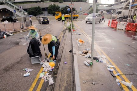 Street cleaners collect rubbish left behind after violent clashes during a protest against a proposed extradition bill with China in Hong Kong