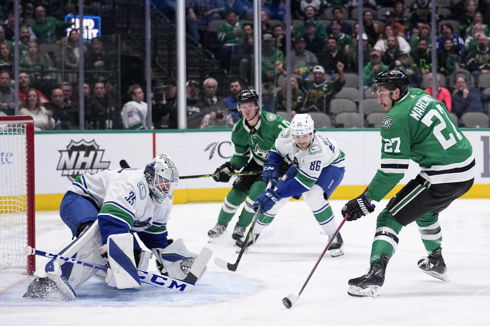Dallas Stars left wing Mason Marchment (27) shoots but is blocked by Vancouver Canucks goaltender Thatcher Demko (35) as Canucks defenseman Christian Wolanin (86) helps defend on the play in the first period of an NHL hockey game, Monday, Feb. 27, 2023, in Dallas. (AP Photo/Tony Gutierrez)