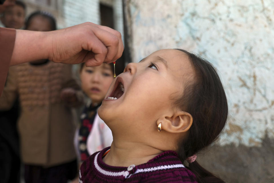 FILE - Shabana Maani, gives a polio vaccination to a child in the old part of Kabul, Afghanistan, March 29, 2021. The Taliban-run Afghan public health ministry announced Sunday, Nov. 7, 2021, the start of a four-day nationwide polio vaccination campaign aimed at inoculating children under age 5. (AP Photo/Rahmat Gul, File)