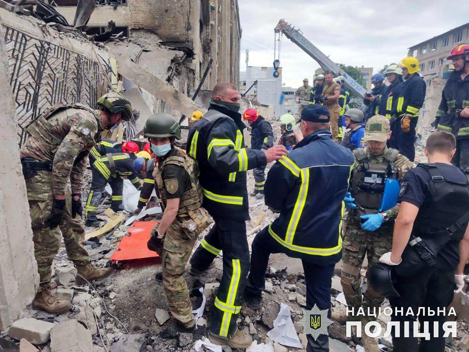 In this photo provided by the National Police of Ukraine, emergency services work next to the Ria Pizza restaurant destroyed by a Russian attack in Kramatorsk on June 28, 2023.