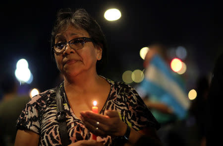 A woman holds a candle during a protest against an increase in utilities prices in Buenos Aires, Argentina, April 19, 2018. REUTERS/Marcos Brindicci