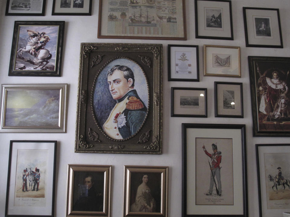 FILE — In this Oct. 15, 2017, file photo, several images of Napoleon Bonaparte are shown in this collection of framed pictures on a wall in the Consulate hotel in Jamestown on St. Helena island in the Atlantic Ocean. Commemorations of the May 5, 1821 death of Napoleon are going ahead on St. Helena, the remote South Atlantic island where the deposed French emperor died in exile. But they are not happening with an influx of international visitors that was expected before COVID-19 swept across the world. While the volcanic island has not had any confirmed COVID-19 cases, reaching it got even harder because of travel restrictions during the pandemic. (AP photo/Christopher Torchia, File)