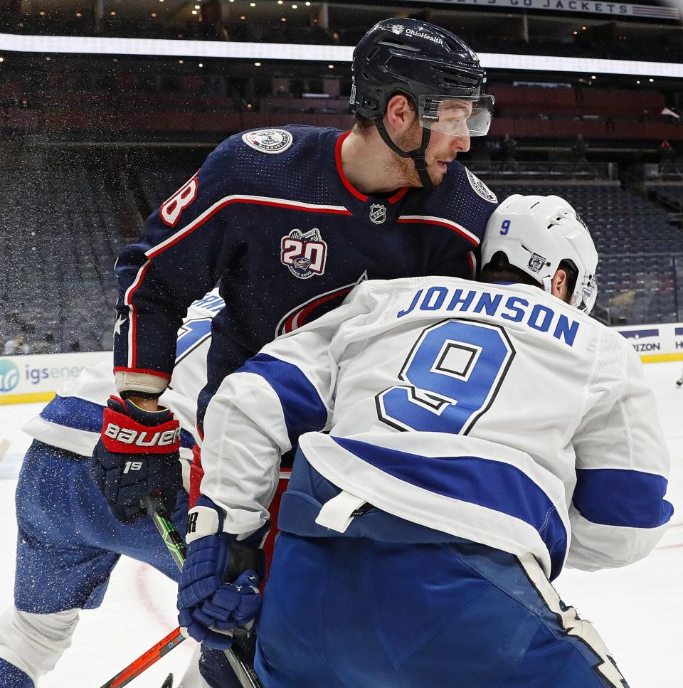 In his final game as a Blue Jacket, center Pierre-Luc Dubois (18) and Tampa Bay Lightning center Tyler Johnson (9) battle for the puck during the first period in the NHL game at Nationwide Arena in Columbus, Ohio on January 21, 2021.