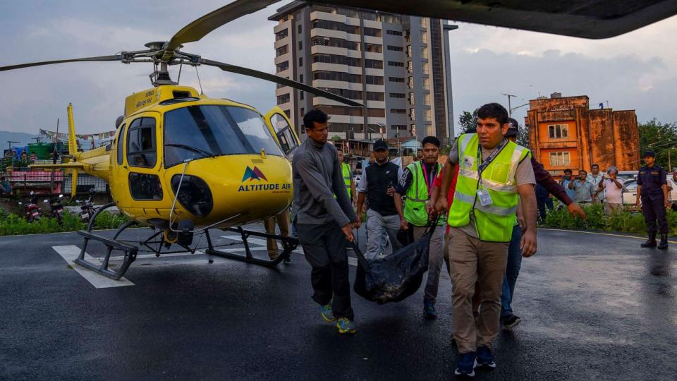 PHOTO: The body of a victim of a helicopter crash is carried out of a chopper in Kathmandu, Nepal, Tuesday, July 11, 2023 (Niranjan Shrestha/AP)