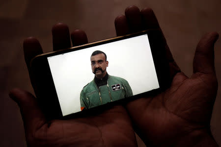 A man watches a statement of Indian Air Force pilot Abhinandan Varthaman on his mobile phone, released on twitter by the Ministry of Information & Broadcasting, in Karachi, Pakistan March 1, 2019. REUTERS/Akhtar Soomro