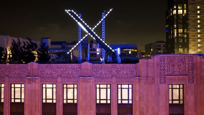Workers install lighting on an “X” sign atop the company headquarters, formerly known as Twitter, in downtown San Francisco, on Friday, July 28, 2023. San Francisco has launched an investigation into the sign, as city officials say replacing letters or symbols on buildings, or erecting a sign on top of one, requires a permit.