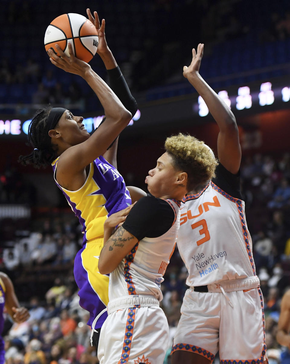 Los Angeles Sparks guard Brittney Sykes shoots over Connecticut Sun guard Natisha Hiedeman and forward Kaila Charles (3) during a WNBA basketball game Saturday, Aug. 28, 2021, in Uncasville, Conn. (Sean D. Elliot/The Day via AP)