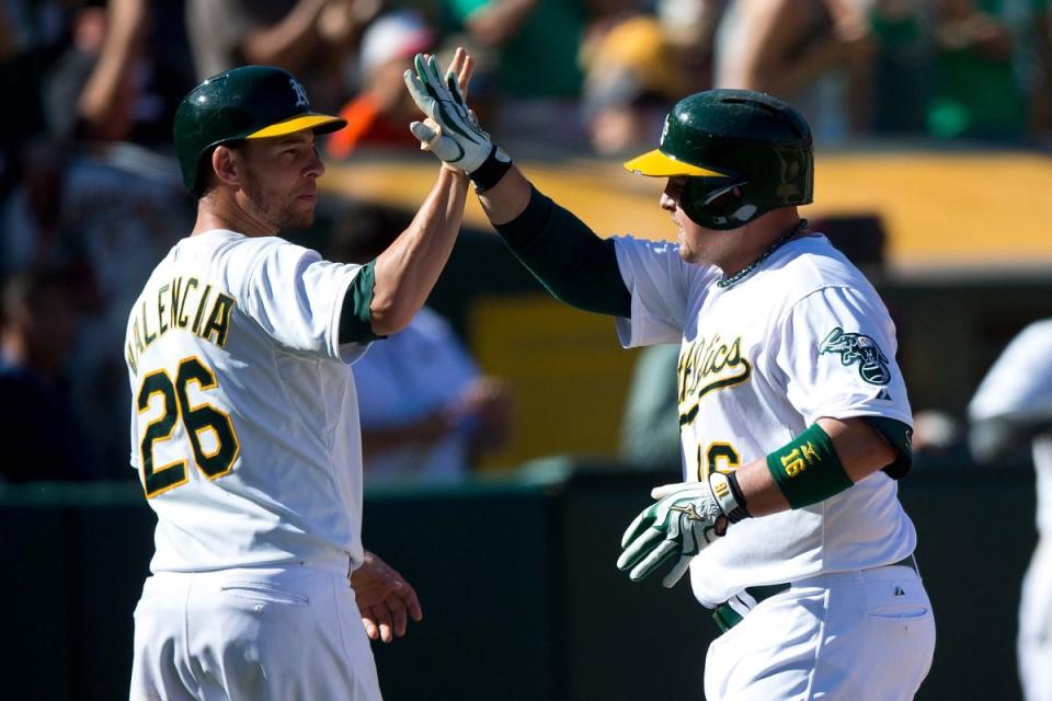 Billy Butler and Danny Valencia share a high-five and not fists during a recent game. (Getty Images/Jason O. Watson)