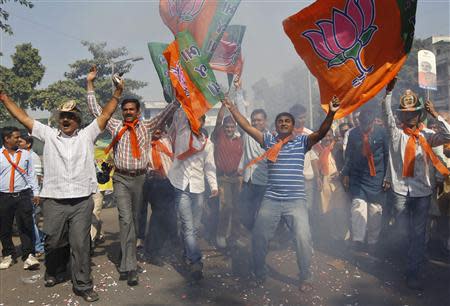 Supporters of India's main opposition Bharatiya Janata Party (BJP) wave party flags as they celebrate outside the party's headquarters in the western Indian city of Ahmedabad December 8, 2013. REUTERS/Amit Dave