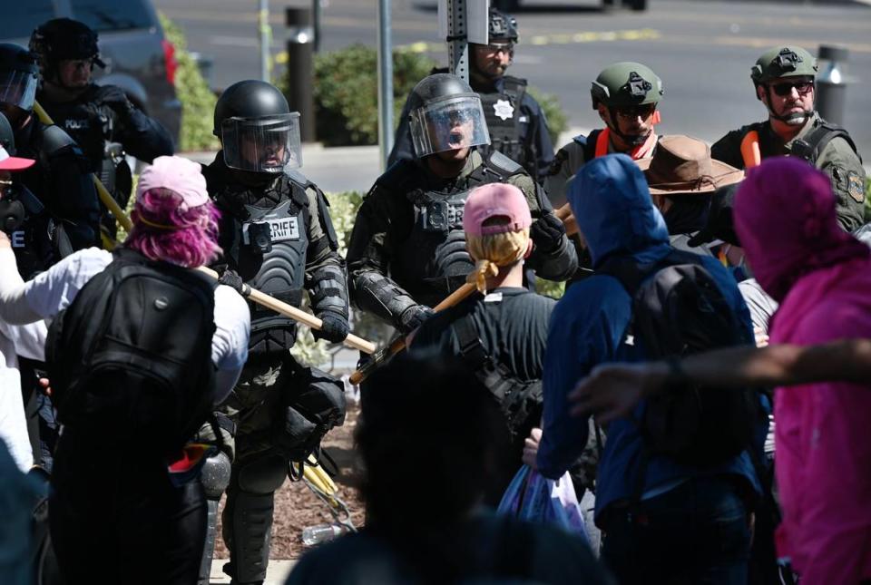 Sheriff’s deputies try and clear the area around the Planned Parenthood office on McHenry Ave during an opposition rally that began as a protest to the Straight Pride event in Modesto, Calif., on Saturday, August 27, 2022.