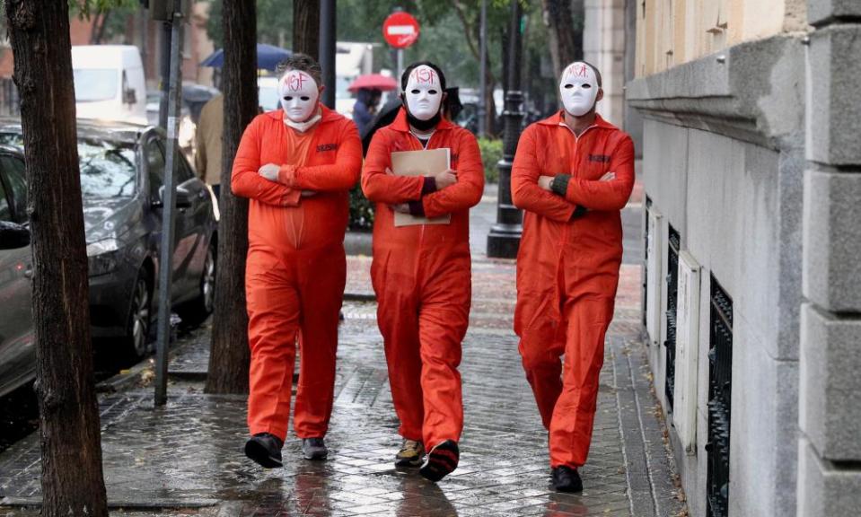 Three masked members of Madrid Without Future walk to hand in a request to support the restaurant and bar sector.