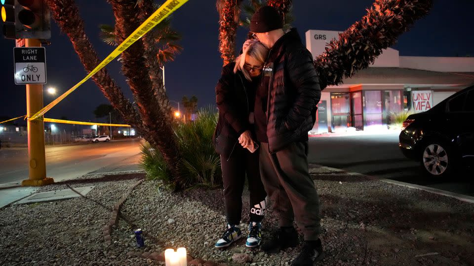 Sean Hathcock, right, kisses Michelle Ashley on Wednesday after the two left candles for victims of the shooting at UNLV. - John Locher/AP