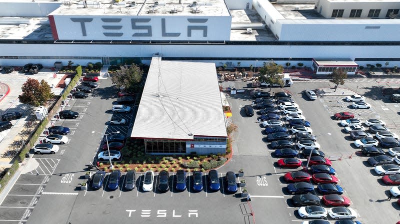 In an aerial view, brand new Tesla cars sit in a parking lot at the Tesla factory on October 19, 2022 in Fremont, California.