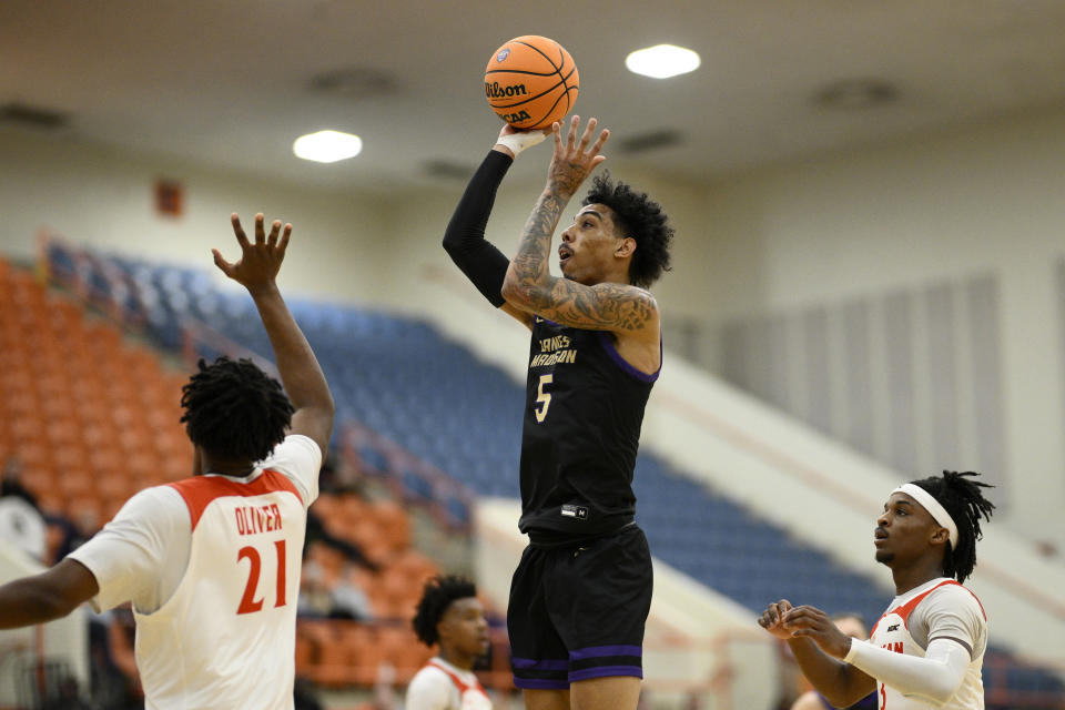 James Madison guard Terrence Edwards (5) shoots against Morgan State forward Christian Oliver (21) and guard Rob Lawson, right, during the first half of an NCAA college basketball game, Friday, Dec. 22, 2023, in Baltimore. (AP Photo/Nick Wass)