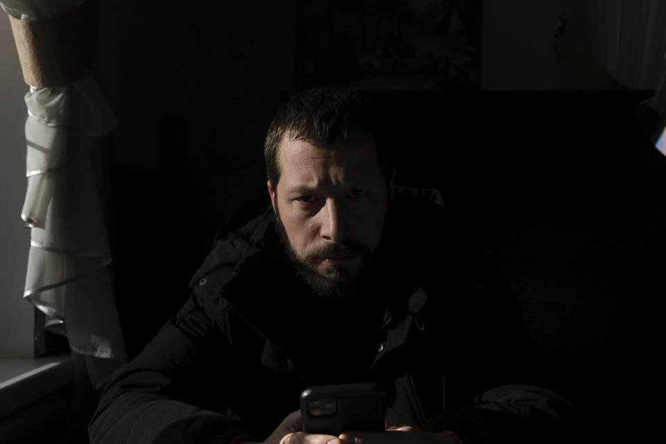 FILE - Associated Press videographer Mstyslav Chernov reads news on his phone three days before the start of Russian invasion in Volnovakha, Ukraine, on Feb. 21, 2022. On the evening of Feb. 23, Chernov headed to Mariupol with colleague Evgeniy Maloletka. Chernov and Maloletka, two Ukrainians who documented the horrors of the Russian invasion and siege of Mariupol for The Associated Press, are being honored for their courage with Colby College's Lovejoy Award. (AP Photo/Evgeniy Maloletka, File)