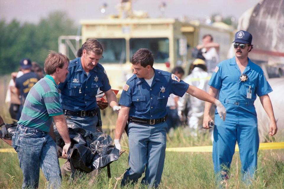 Aug. 31, 1988: Emergency responders carry a victim of Delta Flight 1141 that crashed at Dallas-Fort Worth International Airport.