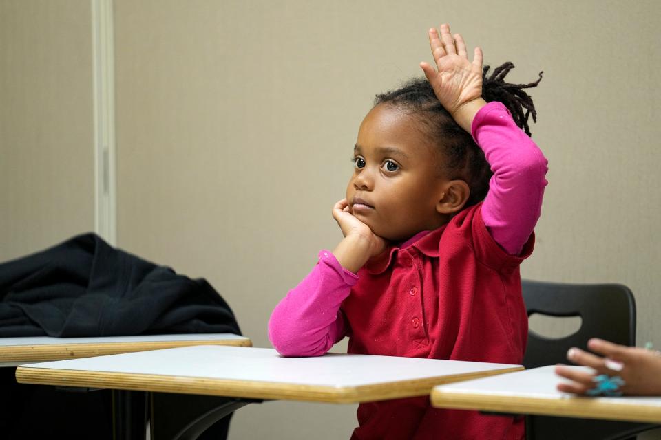 Nova Mallory, 5, raises her hand to answer a question Wednesday, Nov. 1, 2023, during the Read to Lead after school program at the MLK Center in Indianapolis. The program offers reading enrichment and tutoring for students from James Whitcomb Riley Elementary School, with the goal of improving their skills and sparking a love of reading.