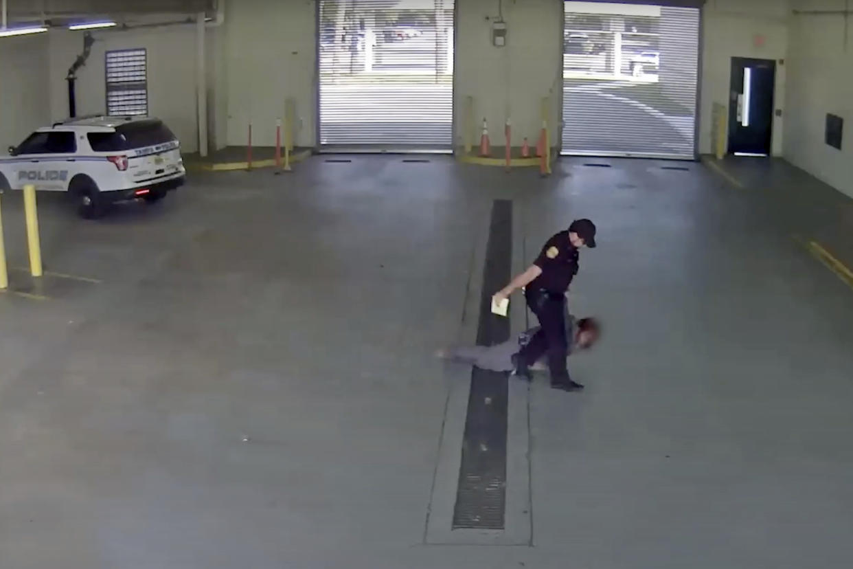 In this image taken from video released by the Tampa Police Department, police officer Gregory Damon drags a woman across the floor at Orient Road Jail in Tampa, Fla., on Nov. 17, 2022. Damon, who was videotaped dragging a handcuffed woman on the floor has been fired, authorities said. An internal investigation determined that former officer violated department policies during the Nov. 17 incident, the Tampa Police Department announced Tuesday, Dec. 27, 2022 in a news release. (Tampa Police Department via AP)