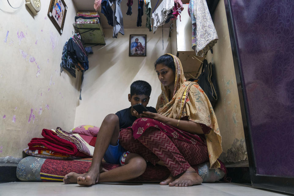 32-year-old woman, Komal Vilas Thatkare, right, learns to use a chatbot powered by artificial intelligence developed by Myna Mahila Foundation, a local women's organization, at her home in Mumbai, India, Feb. 1, 2024. The foundation has recruited 80 test users like Thatkare to help train the bot answer questions about sexual reproductive health. The chatbot, currently a pilot project, represents what many hope will be part of the impact of AI on health care around the globe. (AP Photo/Rafiq Maqbool)