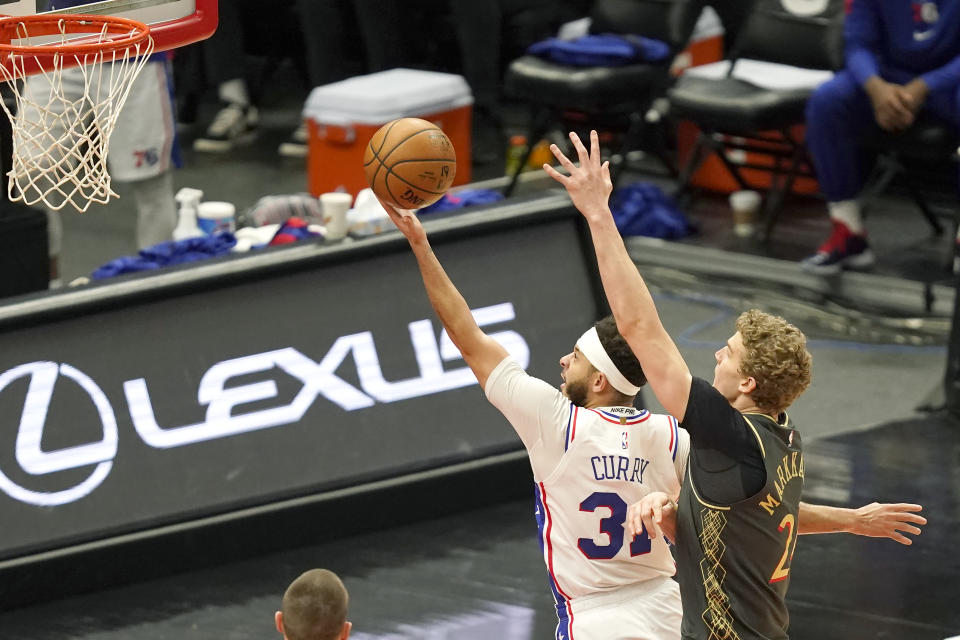 Philadelphia 76ers' Seth Curry, left, drives to the basket past Chicago Bulls' Lauri Markkanen, right, during the first half of an NBA basketball game Monday, May 3, 2021, in Chicago. (AP Photo/Charles Rex Arbogast)