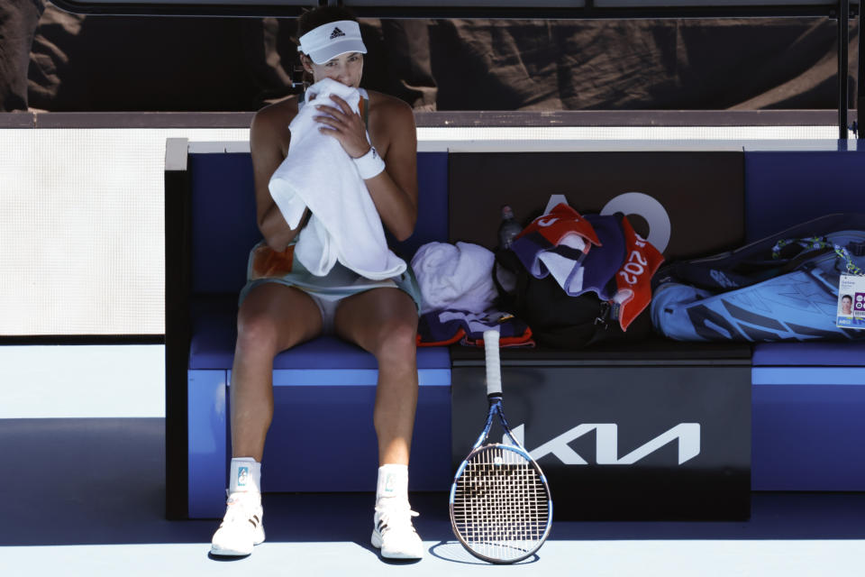 Garbine Muguruza of Spain rests in her chair in a break during her second round match Alize Cornet of France at the Australian Open tennis championships in Melbourne, Australia, Thursday, Jan. 20, 2022. (AP Photo/Hamish Blair)