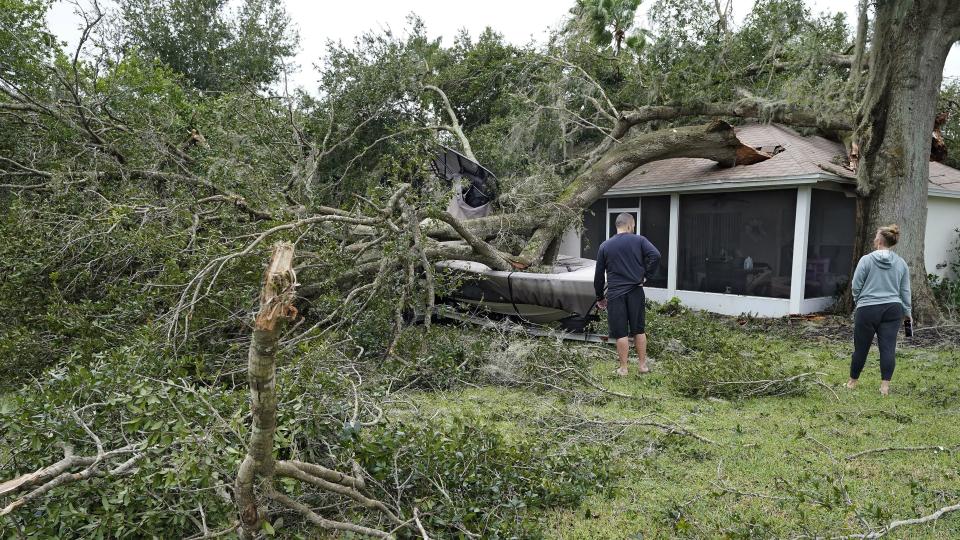 People survey damage to their home in the aftermath of Hurricane Ian, Thursday, Sept. 29, 2022, in Valrico, Fla. (AP Photo/Chris O'Meara)