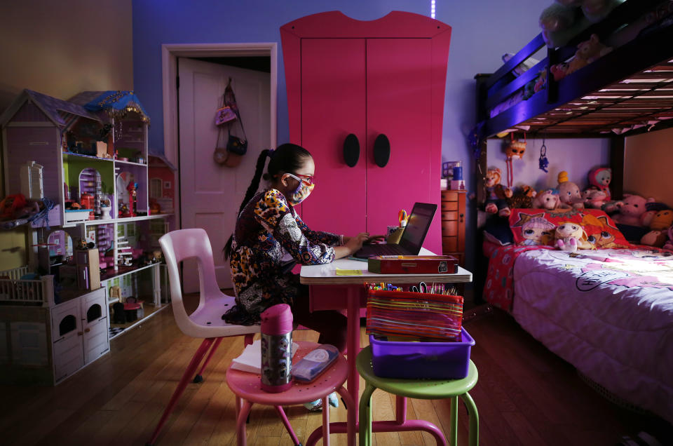 A fourth-grader uses a laptop computer to complete school lessons in her room. (Al Seib /Los Angeles Times)