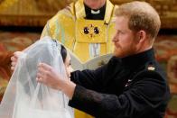 <p>Prince Harry lifts the veil over Meghan Markle's face during their wedding at St George's Chapel in Windsor.</p>