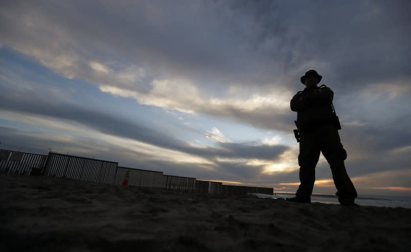 A Border Patrol officer stands watch near the border wall in Imperial Beach