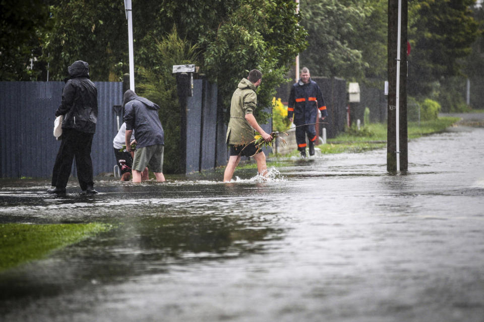 People walk through flood water in Hastings, southeast of Auckland, New Zealand, Tuesday, Feb. 14, 2023. The New Zealand government declared a state of emergency across the country's North Island, which has been battered by Cyclone Gabrielle. (Paul Taylor/Hawkes Bay Today via AP)