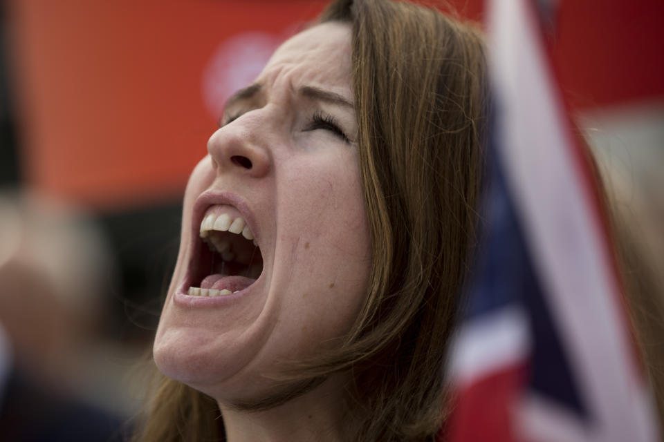 A woman holds a Britain flag as she shouts slogans during an anti Brexit protest outside the European Council headquarters in Brussels, Wednesday, Oct. 17, 2018. European Union leaders are converging on Brussels for what had been billed as a "moment of truth" Brexit summit but which now holds little promise for a breakthrough. (AP Photo/Francisco Seco)