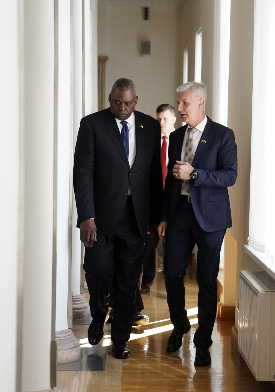 U.S. Secretary of Defense Lloyd Austin, left, and Latvian Minister of Defence Artis Pabriks walk prior their meeting in Riga, Latvia, Wednesday, Aug. 10, 2022. (AP Photo/Roman Koksarov)