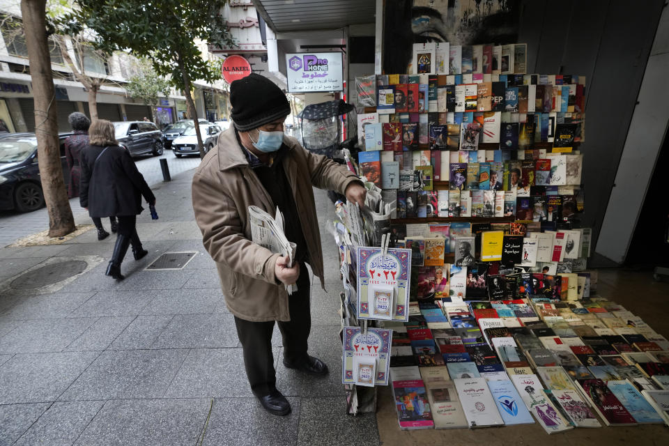 Naim Saleh, a newspapers, magazines and books street vendor, displays newspapers at Hamra street, in Beirut, Lebanon, Friday, Jan. 14, 2022. Saleh a known face in Hamra, said business dropped dramatically adding that he used to sell 50 books a day compared with two a month now. Hamra Street once was home to the region's top movie theaters, shops selling international brands and cafes where intellectuals from around the Arab world gathered. (AP Photo/Hussein Malla)