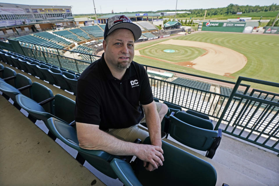 Baseball fan Josh Smith sits in a seat in The Ballpark at Jackson on Tuesday, June 22, 2021, in Jackson, Tenn. When Major League Baseball stripped 40 teams of their affiliation in a drastic shakeup of the minor leagues this winter, Jackson lost the Jackson Generals, the Double-A affiliate of the Arizona Diamondbacks. Smith said he misses going to Generals games with family members and friends. "It was what baseball was always supposed to be," he said. "It's your whole community having a blast." (AP Photo/Mark Humphrey)