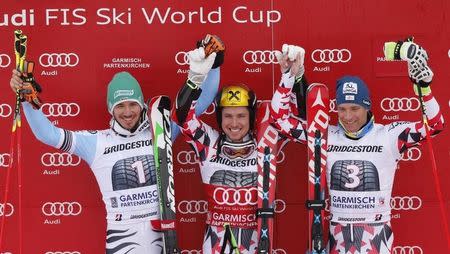 Second placed Felix Neureuther of Germany, first placed Marcel Hirscher of Austria and his third placed compatriot Benjamin Raich (L-R) celebrate on the winners podium after the men's Alpine Skiing World Cup giant slalom in Garmisch-Partenkirchen March 1, 2015. REUTERS/Wolfgang Rattay