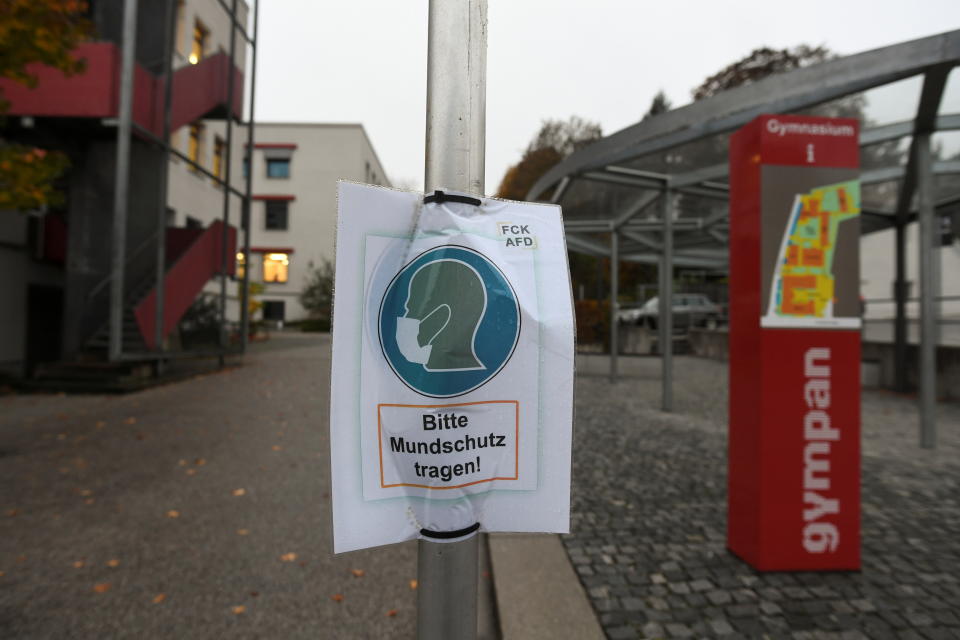 A sign reading "Please wear a face mask" is seen in front of the local high school prior to an ordered lock-down due to the further spreading of the coronavirus disease (COVID-19) in Pfarrkirchen, Germany, October 26, 2020. REUTERS/Andreas Gebert