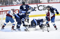 Colorado Avalanche's Joel Kiviranta (94) looks for the loose puck in front of Winnipeg Jets goaltender Connor Hellebuyck (37) during the second period in Game 2 of an NHL hockey Stanley Cup first-round playoff series Tuesday, April 23, 2024, in Winnipeg, Manitoba. (Fred Greenslade/The Canadian Press via AP)