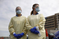 Physicians Assistant Jessica Hamilton, left, and Amena Beslic RN holds a swab and test tube kit to test people for COVID-19 at a drive through station set up in the parking lot of the Beaumont Hospital in Royal Oak, Mich., Monday, March 16, 2020. (AP Photo/Paul Sancya)