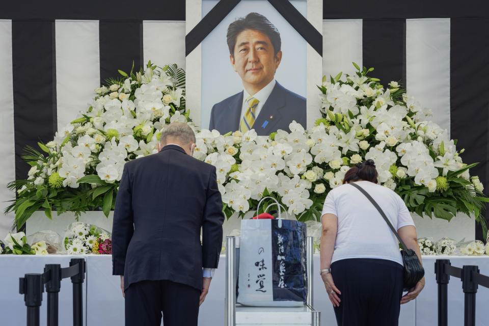 Personas dejan flores y presentan sus respeto al ex primer ministro de Japón Shinzo Abe a las afueras de Nippon Budokan, el martes 27 de septiembre de 2022, en Tokio. (Nicolas Datiche/Pool Photo via AP)