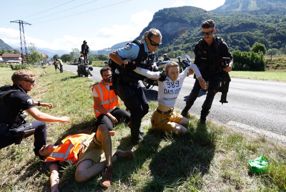 Police officers remove protestors from the road (Reuters)