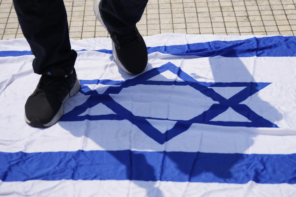 A man steps on an Israeli flag during a protest outside national mosque after the Friday prayer in Kuala Lumpur, Malaysia, Friday, Oct. 13, 2023. (AP Photo/Vincent Thian)